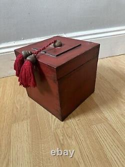 Grande boîte chinoise en bois laqué antique avec pompons rouges.