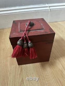 Grande boîte chinoise en bois laqué antique avec pompons rouges.