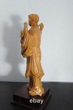 Grande figure féminine en bois dur finement sculpté de Chine, sur socle antique, du XXe siècle.