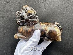 Grande sculpture chinoise Qing en pierre dure russet antique représentant une bête couchée.