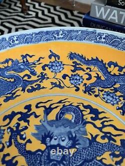 Une grande assiette en porcelaine chinoise ancienne jaune avec un dragon bleu et une marque Qianlong