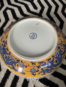 Une grande assiette en porcelaine chinoise ancienne jaune avec un dragon bleu et une marque Qianlong